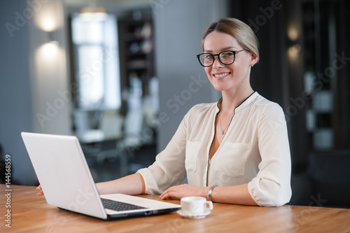 The woman working at the table. Looks at you and smiles.