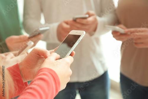 People standing together and using smartphones, closeup