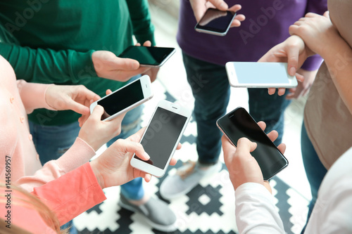 People standing in circle and using smartphones  closeup