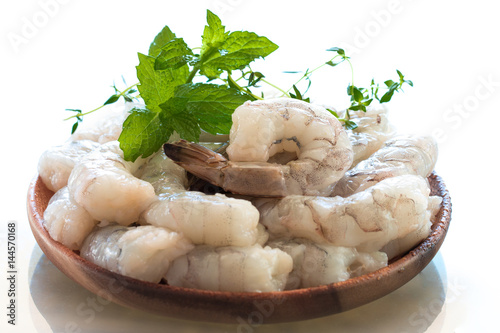 Raw shrimps in wooden plate.