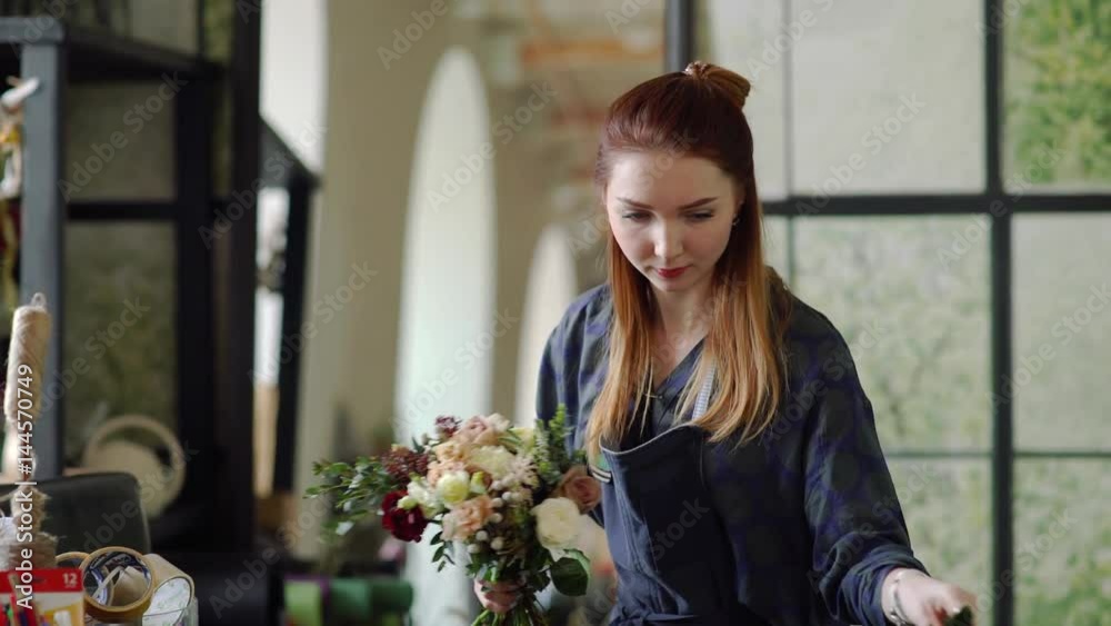 Florist arranging some flowers.Florist girl makes a bouquet in a flower salon Florist arranging some flowers.Florist girl makes a bouquet in a flower salon