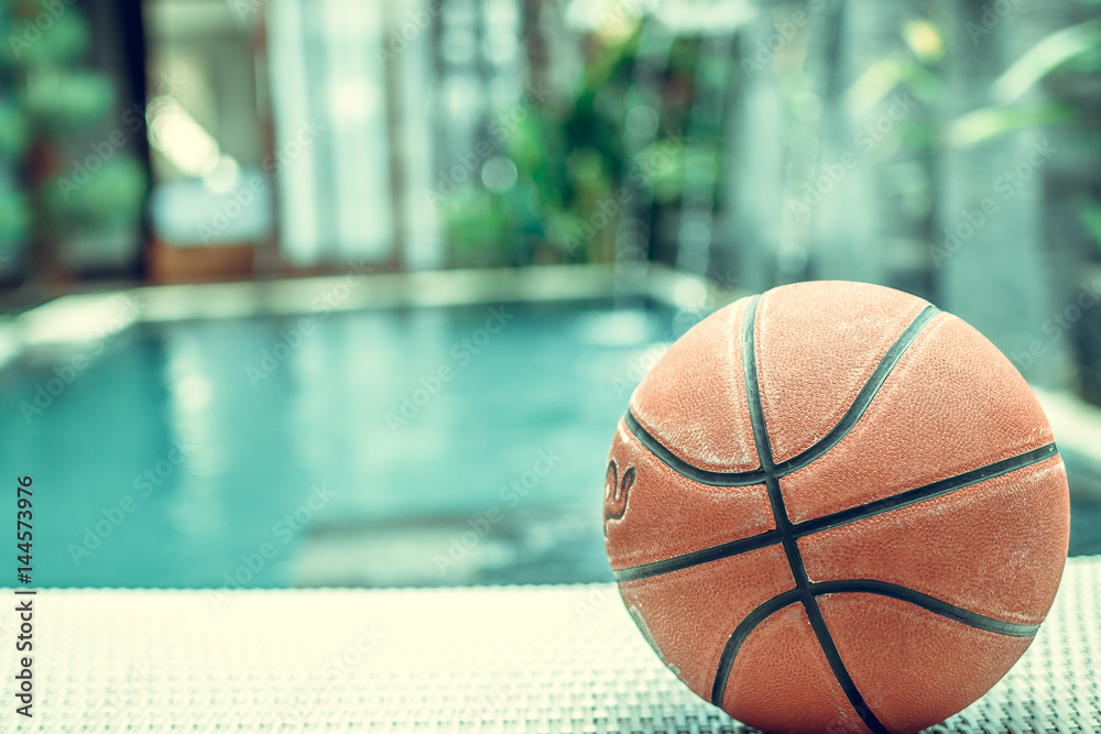 Basketball ball on a swimming pool background, tropical sport scene. Basketball ball on a swimming pool background, tropical sport scene.