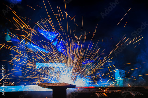 Photos Worker is welding automotive part in car factory