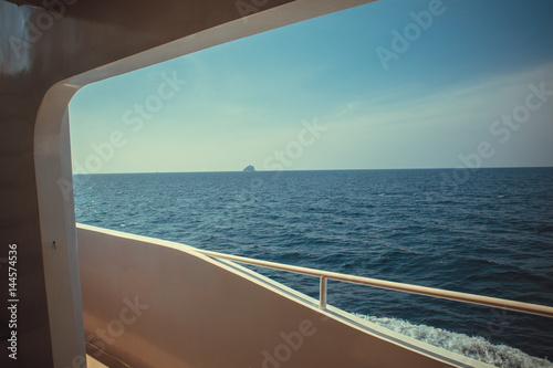 Luxury ship yacht window with a relaxing seascape ocean and blue sky view.