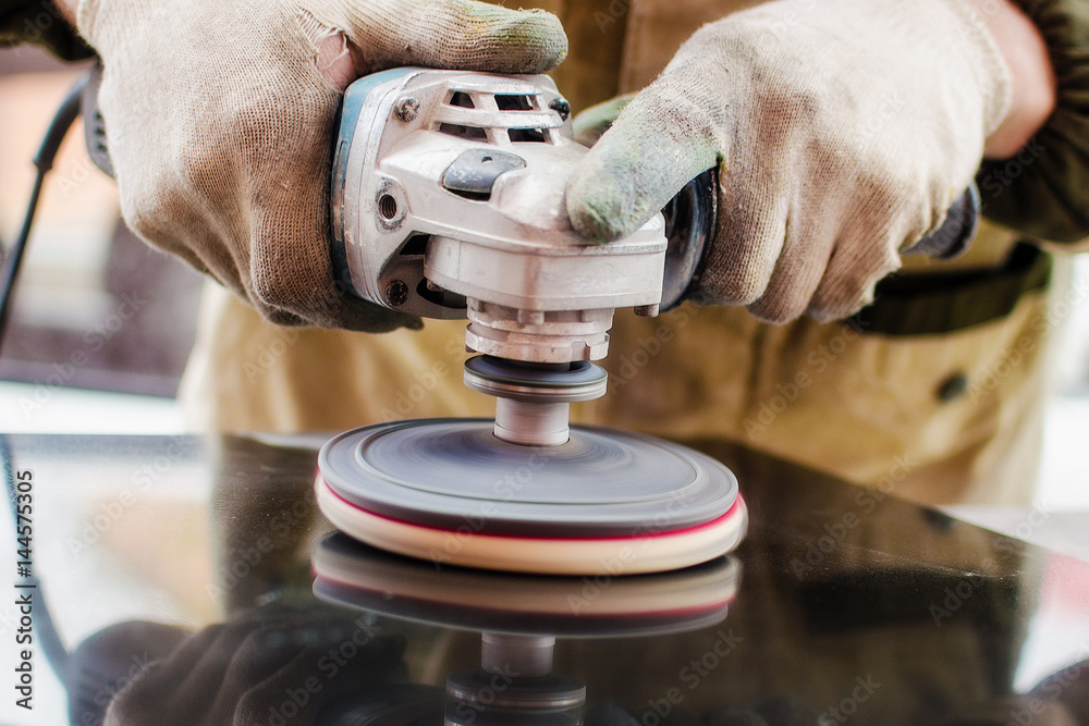 Worker polishes a stone with a grinder