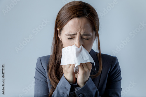 young woman blowing her nose. allergic rhinitis. hay fever. photo