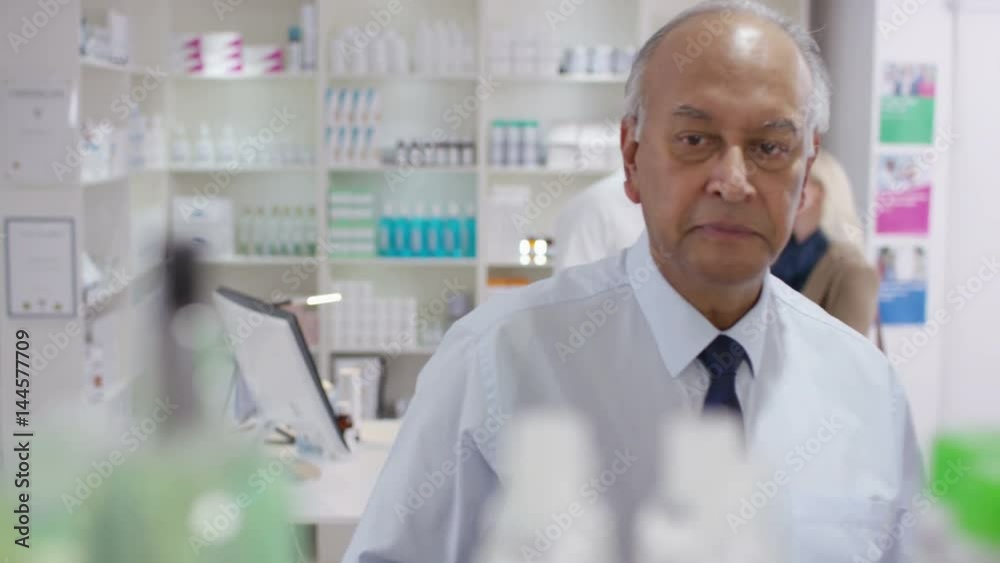 Team of staff working & serving customers in a chemist shop Team of staff working & serving customers in a chemist shop