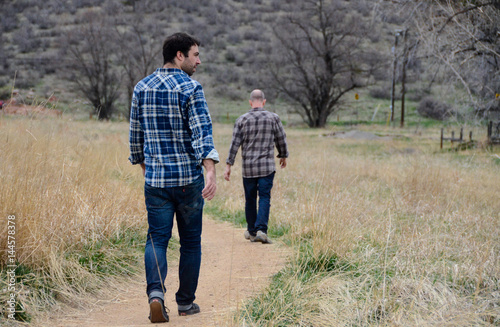 Two men walking along dirt track
