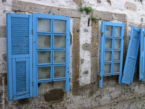 Blaue Holzfenster mit Fensterläden vor zugemauerten Fenstern eines Haus in den Gassen der Altstadt von Alacati bei Cesme am Ägäischen Meer in der Provinz Izmir in der Türkei photo