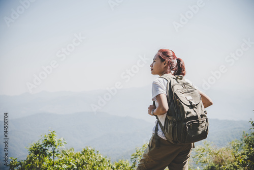 Woman traveler with backpack on beautiful summer landscape.