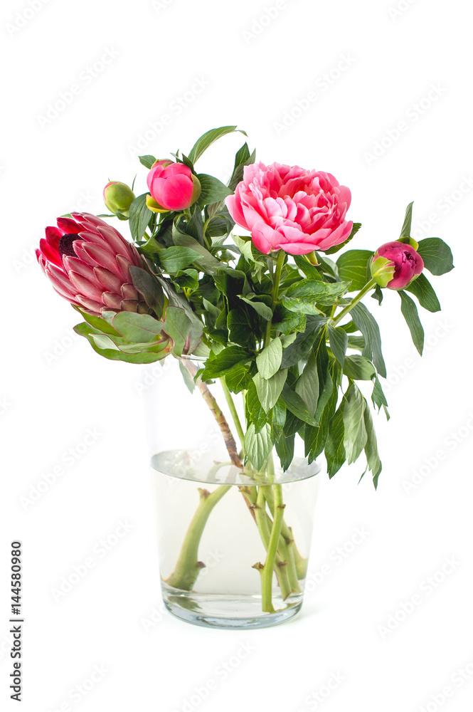 Bright bouquet of freshly cut flowers in a glass vase on a clean white background..