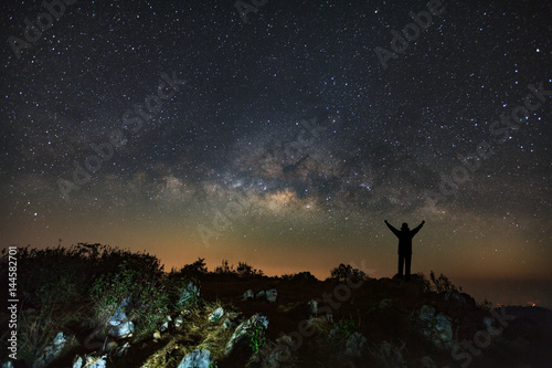 Landscape with milky way, Night sky with stars and silhouette of a standing man on Doi Luang Chiang Dao mountain, Long exposure photograph, with grain