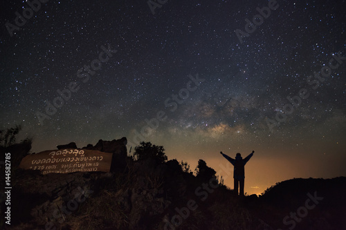 Doi Luang Chiang Dao, Chiang Mai - Febuary 13, 2016 : Milky way galaxy and silhouette of a standing happy man at Doi Luang Chiang Dao High moutaun top point signs.