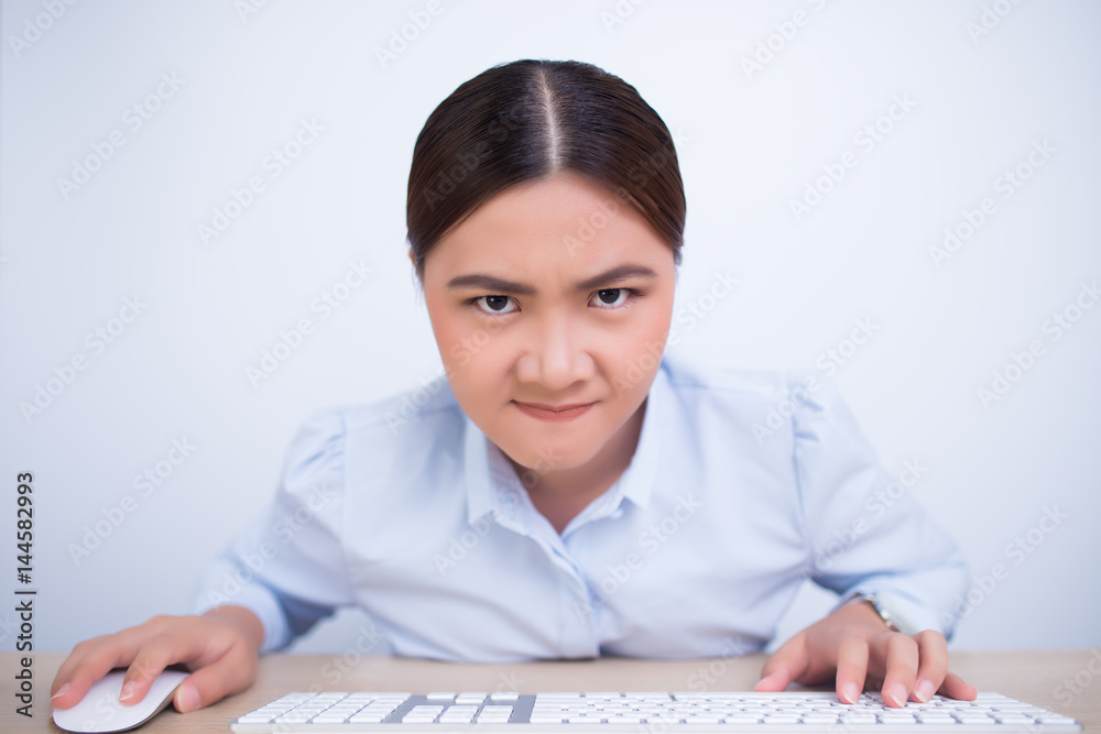 Angry woman use computer look at the camera on isolated background Angry woman use computer look at the camera on isolated background