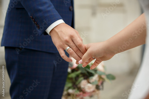 Wedding couple in love, hands of bride and groom, wedding ring on finger © Wedding photography