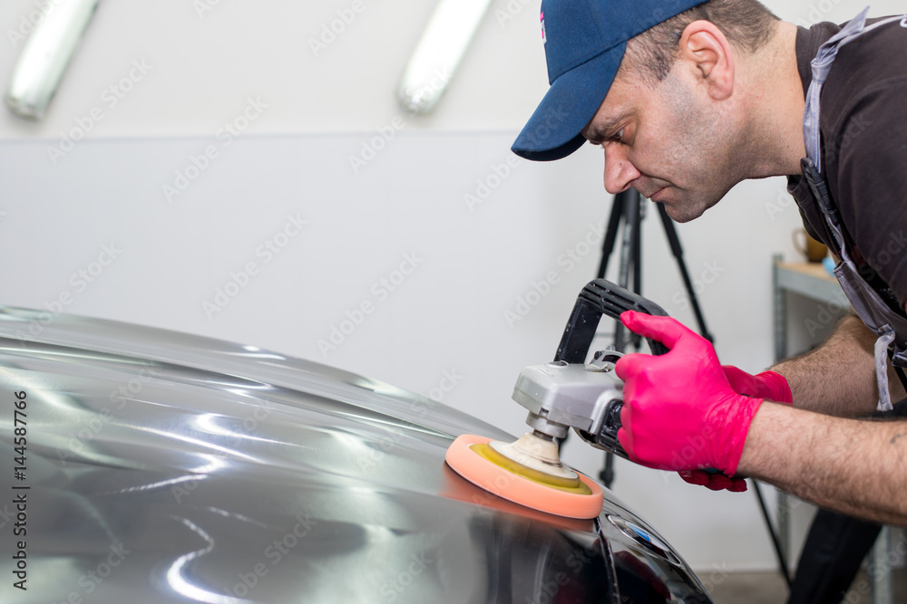 A man polishes a black car A man polishes a black car