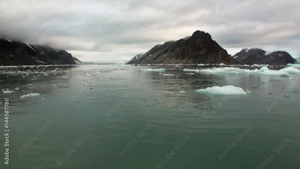 Moving Ice Floes on background of mountain on water of Arctic Ocean in Svalbard. Wildlife in Nordic badlands. Unique footage on background natural landscape and snow of Spitsbergen. Moving Ice Floes on background of mountain on water of Arctic Ocean in Svalbard. Wildlife in Nordic badlands. Unique footage on background natural landscape and snow of Spitsbergen.