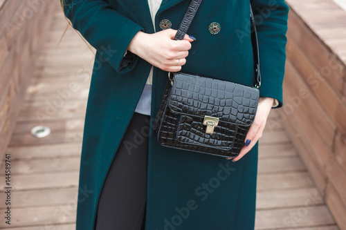 Cassic coat with leather handbag Stylish fashion model outdoor.