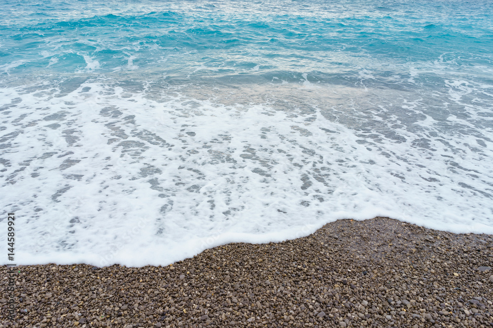 Soft gentle waves with foam in blue ocean italy coast, summer vacation as background