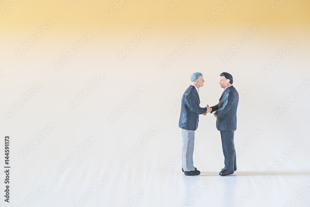 business miniature people make handshaking agreement