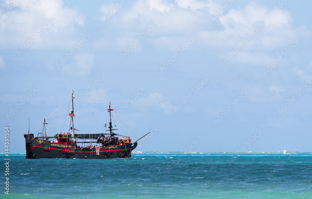 Pirate ship sailing in the Caribbean sea. The boat composed to the left.
