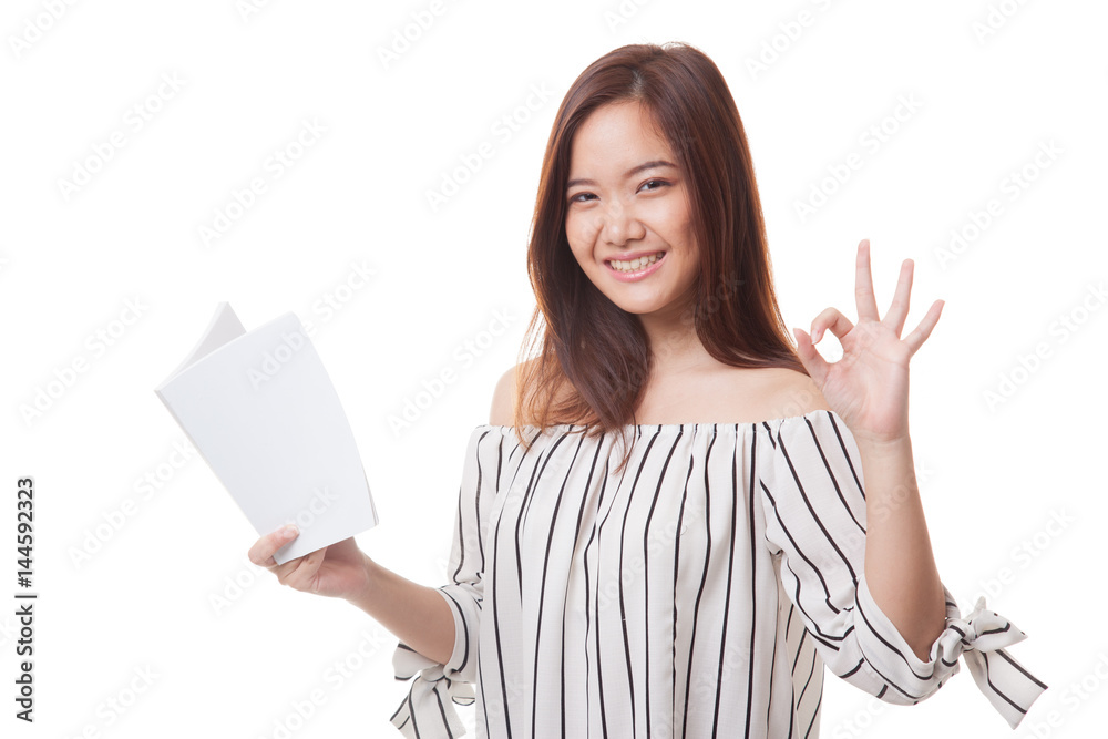 Young Asian woman show OK with a book. Young Asian woman show OK with a book.