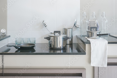 Stainless steel kitchenware on black top counter