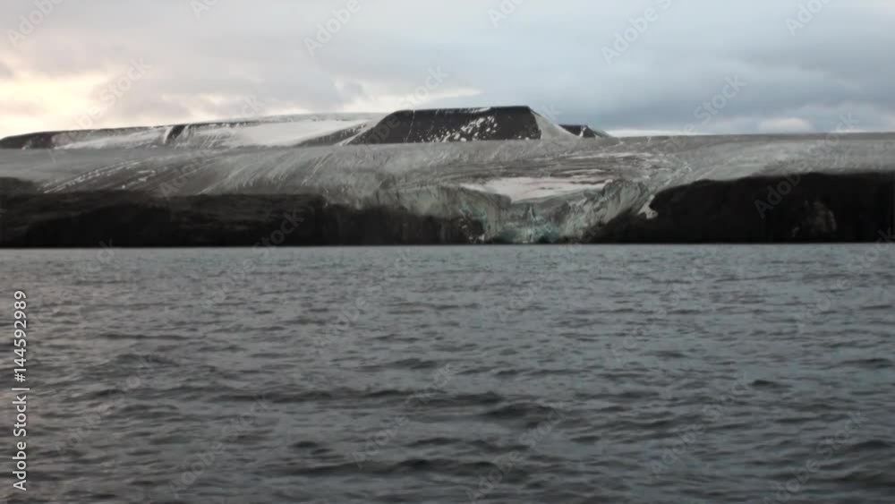 Amazing landscape of mountains on background water of Arctic Ocean in Svalbard. Wildlife in Nordic badlands. Unique footage on background snow of Spitsbergen. Amazing landscape of mountains on background water of Arctic Ocean in Svalbard. Wildlife in Nordic badlands. Unique footage on background snow of Spitsbergen.