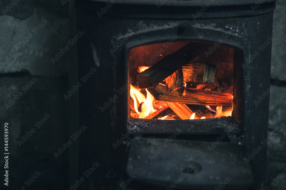 Fire burning in black iron stove. Closeup