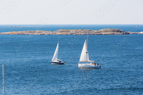 Two sailboats sailing on the coast