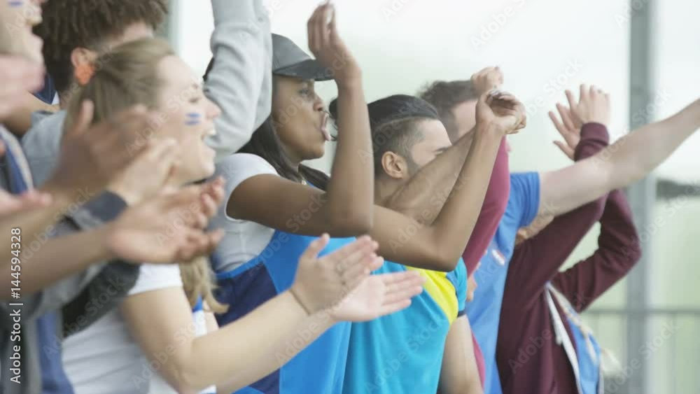 Excited sports fans at live event clapping & cheering for their team Excited sports fans at live event clapping & cheering for their team