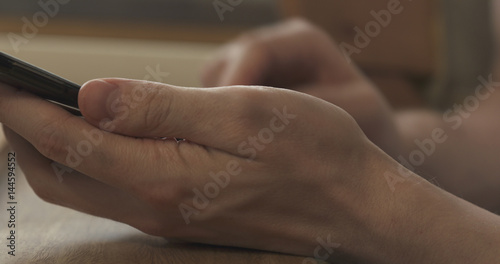 young man hands using smartphone sitting at the table closeup  4k photo