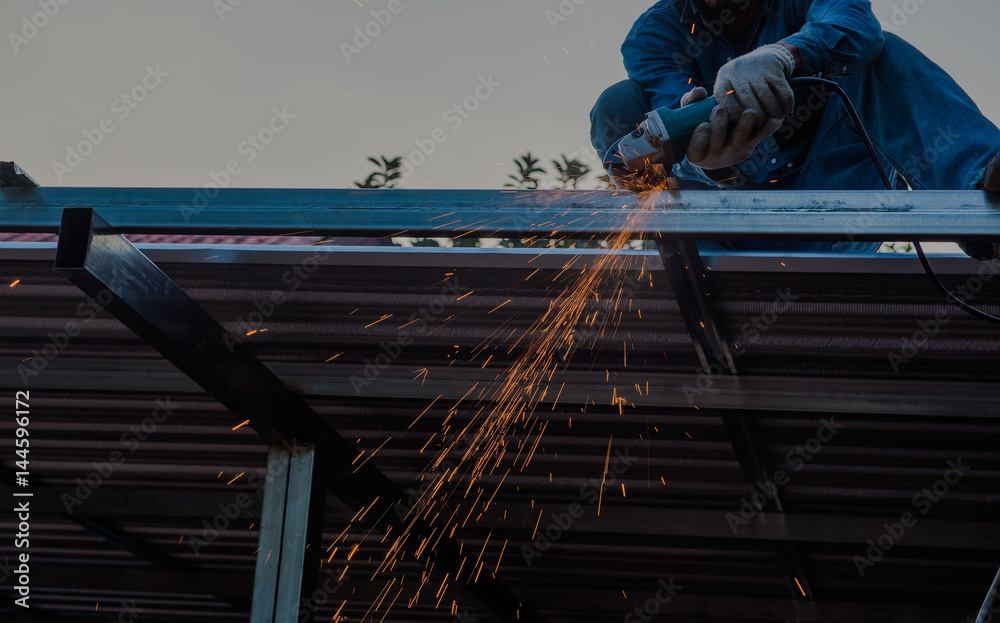 Naklejka premium cuts metal by the male worker with many sparks in industrial steel.