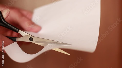 Cutting white paper with scissors