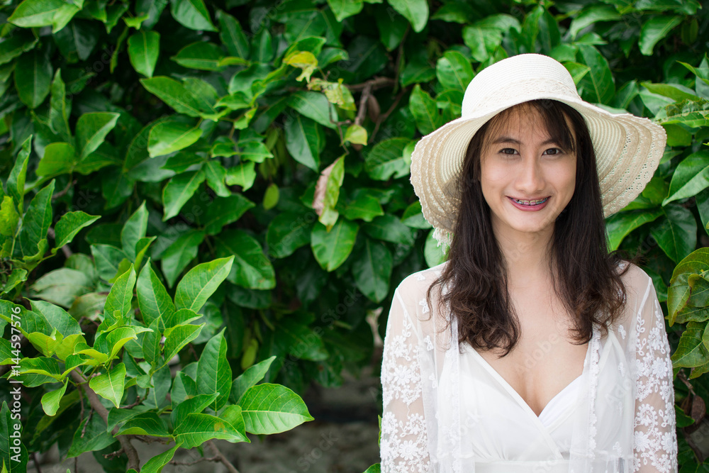 Fashion woman and white hat relax on the beach vegetation background Fashion woman and white hat relax on the beach vegetation background