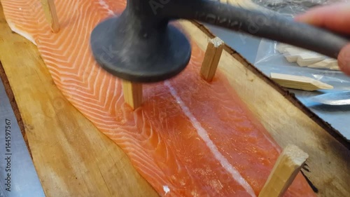 Blazing salmon, tapping glace salmon fillet on a wooden plate, at a restaurant kitchen