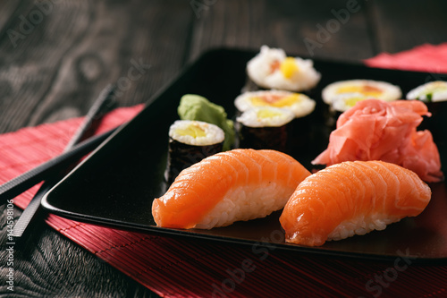 Sushi assortment with ginger and vasabi on black plate. photo