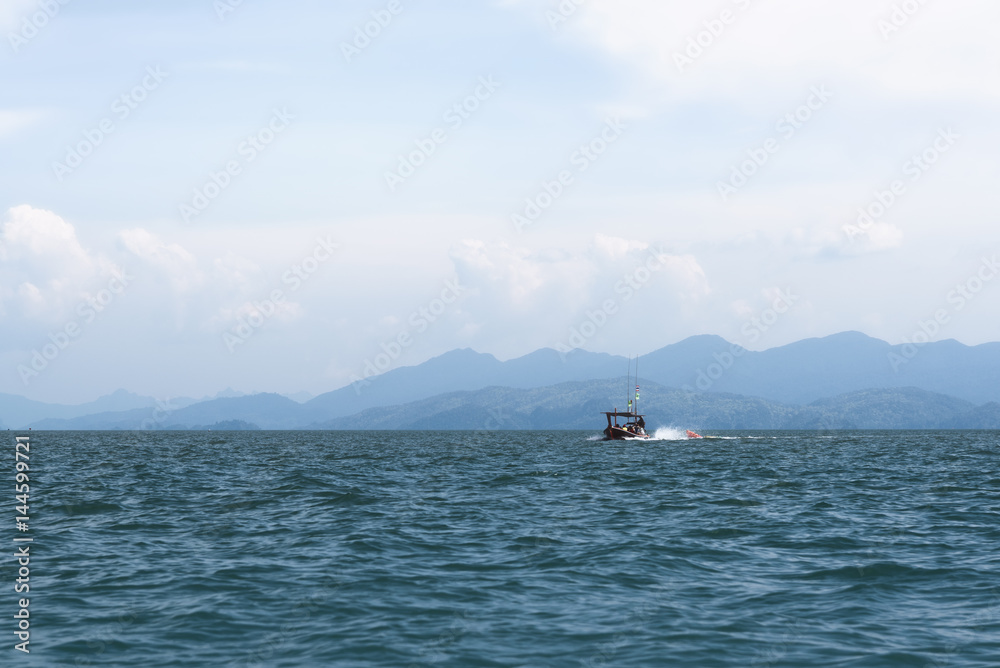 Longtail boat on the sea with island background in Satun, Thailand Longtail boat on the sea with island background in Satun, Thailand