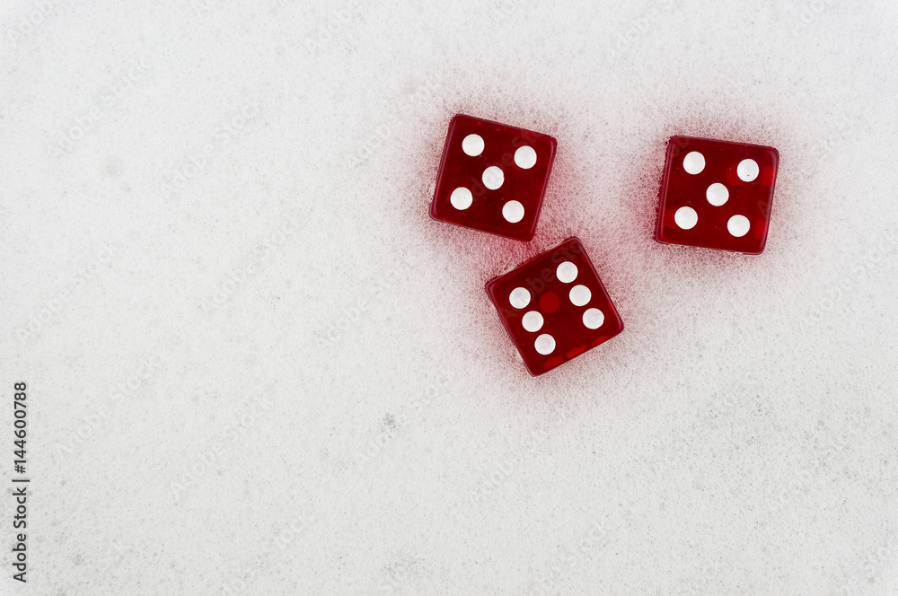 Red dice on a light background. Dice on soapy foam. Red dice on a light background. Dice on soapy foam.