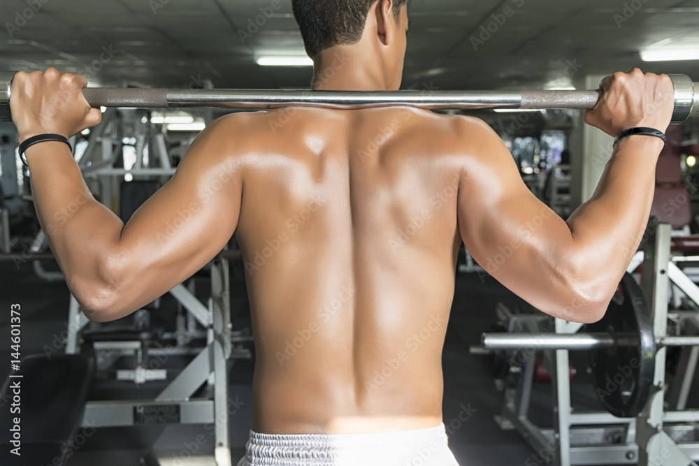 Fitness man in training, showing exercises lifting barbells in the gym Fitness man in training, showing exercises lifting barbells in the gym
