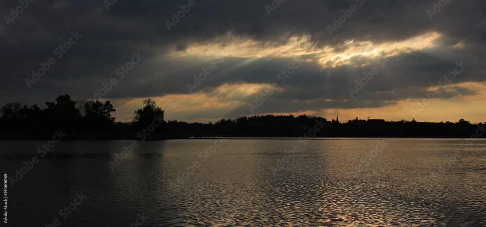 Sunbeams breaking trough clouds over lake Pfaffikon.