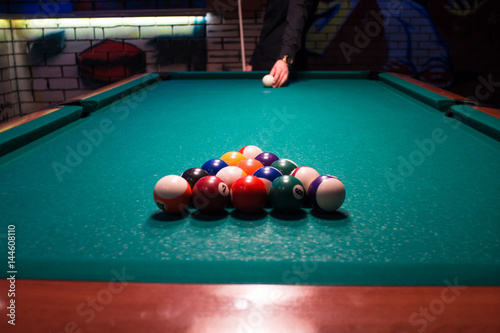 A young man is going to play American billiards pool
