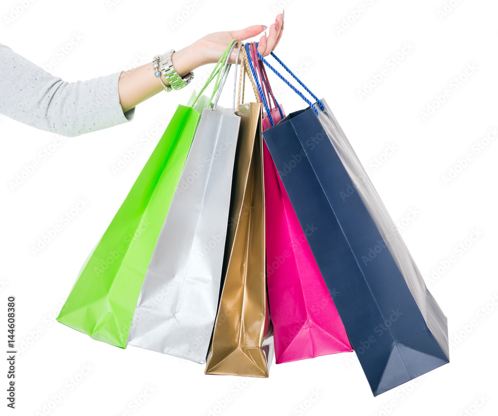 Shopping Bags. Female hand holding colorful shopping bags on white..