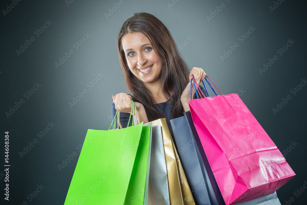 Portrait of young happy smiling woman with shopping bags credit card and shoes.