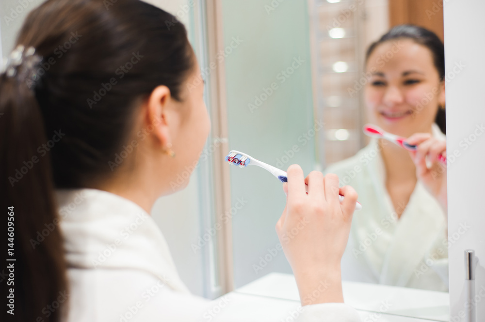 Portrait of young beautiful woman brushing her teeth with toothbrush Portrait of young beautiful woman brushing her teeth with toothbrush