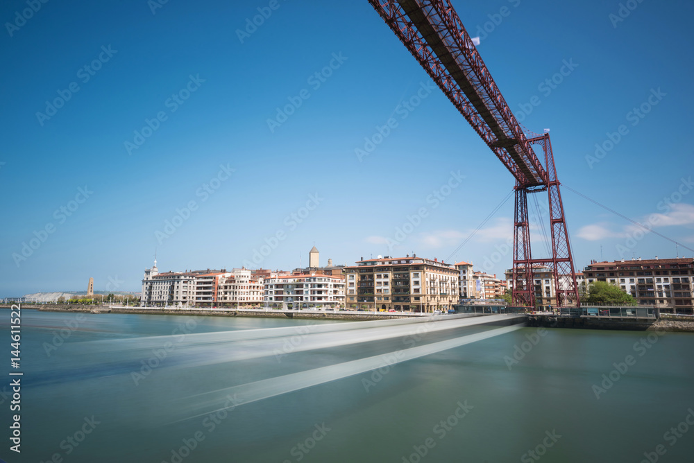 Obraz premium Daylight long exposure of Vizcaya hanging bridge and Nervion river in Portugalete, Bilbao, Spain.