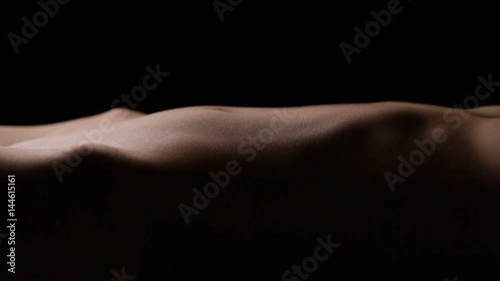 Slim beautiful body of unrecognizable female. Vertical panning. Seamless loop