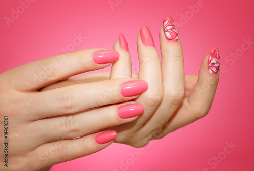 Manicured woman's nails with pink nailart with flowers. photo