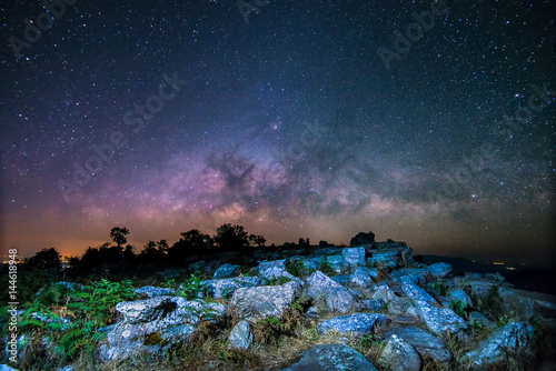 Stone lodge on night sky stars background with milky way