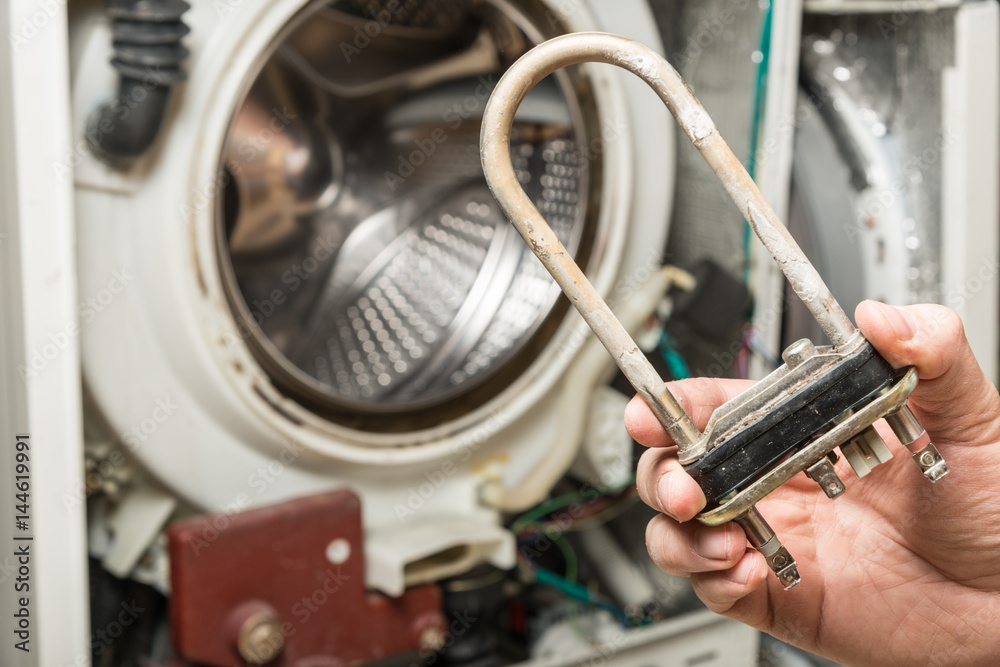 Obraz premium Repair old laundry washer. Extracting the broken heater.